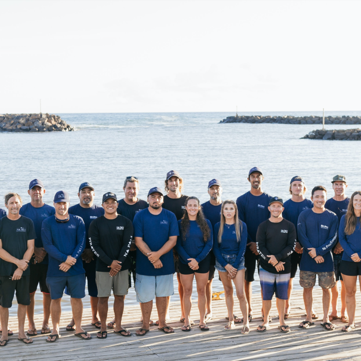a group of people posing in front of a body of water